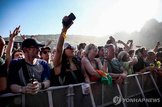 FRANCE-MUSIC-FESTIVAL 지난 24일(현지시간) 프랑스 파리 교외 생클루에서 열린 음악 축제에서 북아일랜드 힙합그룹 니캡의 공연에 환호하는 관객들.[AFP=연합뉴스. 재판매 및 DB 금지]