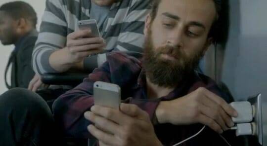 아이폰 사용자가 벽에 가까이 기대서 충전하고 있는 모습을 보여준 과거 갤럭시S25 광고 (사진=삼성전자 유튜브 채널 캡쳐)