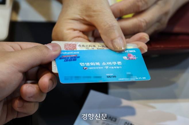 민생회복 소비쿠폰 1차 신청이 시작된 7월 21일 서울 동작구 대방동주민센터에서 한 주민이 선불카드를 발급받고 있다. 성동훈 기자