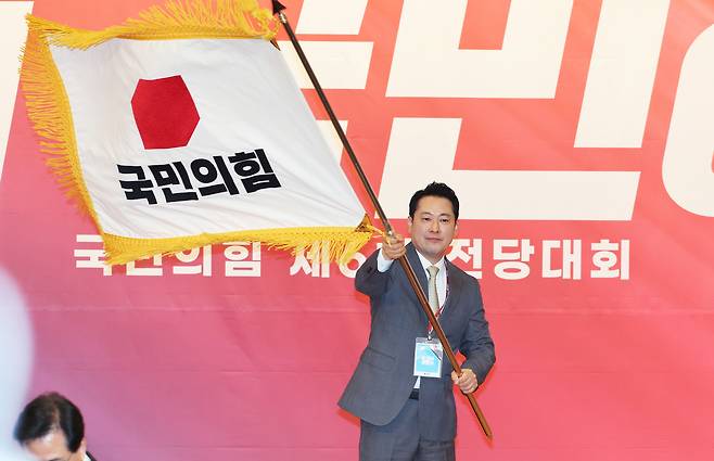 장동혁 국민의힘 신임 당대표가 26일 서울 여의도 국회도서관에서 열린 국민의힘 제6차 전당대회 결선에서 선출된 뒤 당기를 흔들고 있다. 국회사진기자단