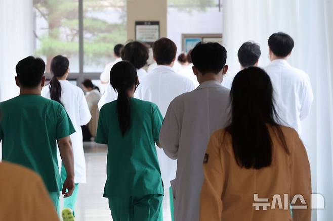 [서울=뉴시스] = 권창회 기자 = 의대 증원 등에 반대해 병원을 떠난 전공의들이 정부의 사직서 수리 금지 명령이 위법하고, 수련병원이 사직서를 수리하지 않아 재산상 손해를 입었다며 제기한 손해배상 소송이 시작됐다.  사진은 11일 서울 시내 대학병원에서 의료진들이 이동하는 모습. 2025.08.11. kch0523@newsis.com
