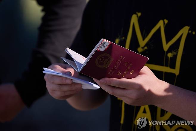 지난해 6월 한 중국인이 미국-멕시코 국경이 있는 캘리포니아주 제이쿰바에서 입국 심사를 받기 위해 여권을 들고 대기하고 있다. [EPA=연합뉴스]