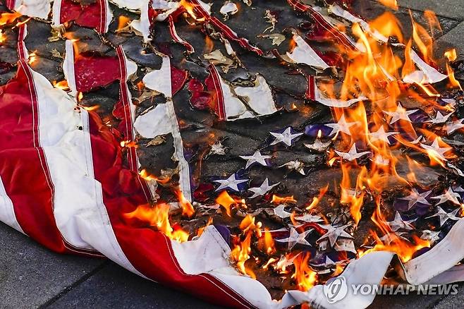 2022년 6월 제이랜드 워커 사건에 항의하는 시위에서 불타는 성조기 [AP 연합뉴스 자료사진. 재판매 및 DB 금지]