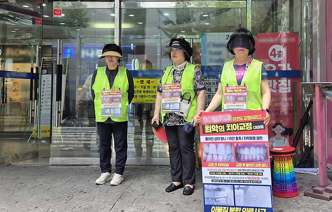 성남시 한 치과에서 의료사고를 당했다고 주장하는 A씨의 가족과 친인척이 27일 치과가 입점한 건물 앞에서 사과와 보상을 요구하며 시위를 하고 있다.
