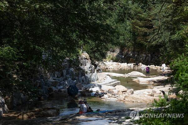 절기상 가을을 맞이한다는 '처서'를 앞두고 폭염이 기승을 부린 22일 경기도 양주시 북한산에서 피서객들이 계곡물로 더위를 식히고 있다. /연합뉴스