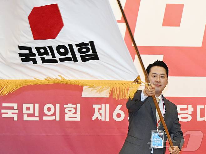 장동혁 국민의힘 신임 당대표가 26일 오전 서울 여의도 국회 도서관에서 열린 제6차 전당대회 결선에서 당기를 흔들고 있다. 2025.8.26/뉴스1 ⓒ News1 국회사진기자단