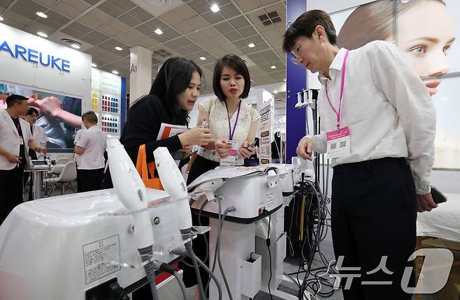 28일 서울 강남구 코엑스에서 열린 ‘2025 서울국제화장품미용산업박람회, 국제건강산업박람회(코스모뷰티서울, 헬스&뷰티위크)’를 찾은 외국인 관람객이 미용기기를 살펴보고 있다.2025.5.28/뉴스1 ⓒ News1 박세연 기자