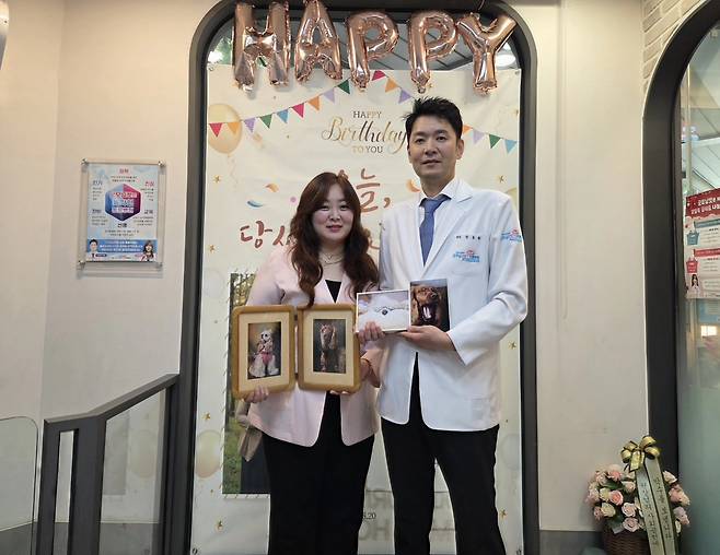 굿모닝펫동물병원 장봉환 원장(오른쪽)과 유희진 실장이 무지개다리를 건넌 무아와 뚜아 사진을 들고 사진을 찍고 있다. ⓒ 뉴스1