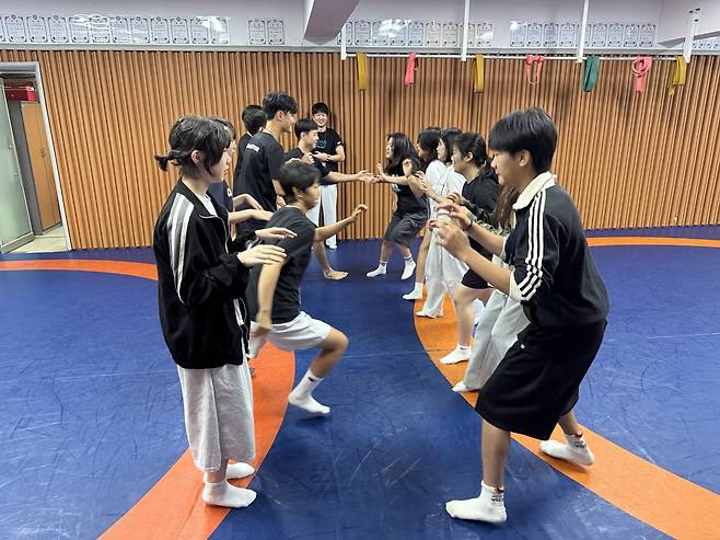 고척중 레슬링 학생 선수들이 스포츠 기반 교과 융합 수업을 하기 전서로 어색함을 없애려고 눈을 맞추고 가벼운 농담을 건네는 아이스브레이킹 게임을 하고 있다. 한국체육진로교육협회 제공
