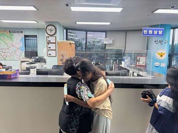 대학금 등록금을 찾은 외국인 유학생과 시민이 포옹을 하고 있다. [사진=부산 남부경찰서]