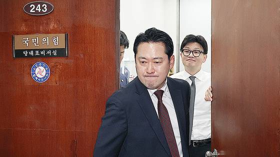 지난해 12월 11일 당시 국민의힘 장동혁 의원이 국민의힘 당대표실을 나가는 사이 한동훈 국민의힘 전 대표가 미소를 짓고 있다. 사흘 뒤 장 의원은 최고위원직을 사퇴하며 한동훈 대표 체제의 붕괴를 이끌었다. 연합뉴스