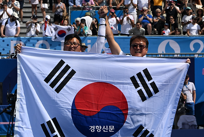 김우진(왼쪽)이 지난 2024년 8월4일(현지시간) 프랑스 파리 앵발리드에서 열린 2024파리올림픽 양궁 남자 개인 결승 미국 브래디 엘리슨과 경기에서 금메달을 따고 박성수 감독과 세리머니를 하고 있다. 파리=올림픽사진공동취재단