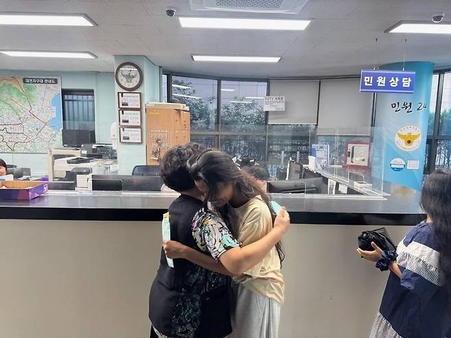 스리랑카 유학생 A씨가 등록금 100여만원이 든 봉투를 되찾아 준 시민 B씨와 부산 대연지구대에서 포옹하고 있다. 부산 남부경찰서 제공