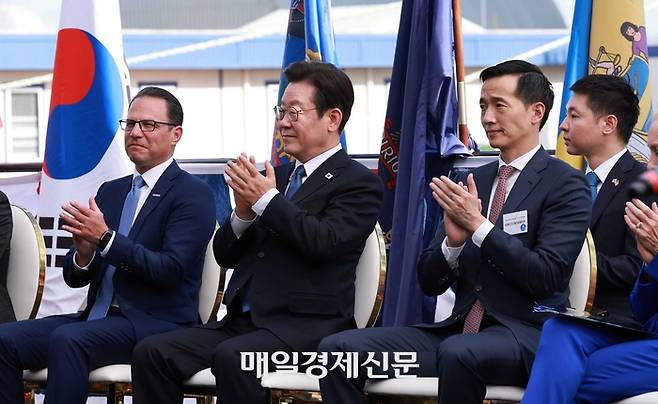 이재명 대통령이 26일(현지시간) 미국 필라델피아에 위치한 ‘한화 필리조선소’에서 열린 미국 해양청이 발주한 국가안보다목적선 ‘스테이트 오브 메인(State of Maine)’호의 명명식에 참석해 박수를 치고 있다. 사진 왼쪽부터 조시 샤피로 펜실베니아 주지사, 이대통령, 김동관 한화그룹 부회장.  [필라델피아/김호영기자]