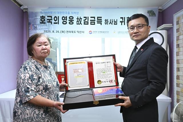 고 김금득 하사 유가족 대표인 고인의 외동딸 김순임(71)씨가 이근원 국방부유해발굴감식단장으로부터 ‘호국의 얼 함’을 전달받은 후 기념사진을 촬영하고 있다. 함 내부에는 고인의 유해와 함께 발굴된 인식표가 담겨 있다. 국방부유해발굴감식단 제공