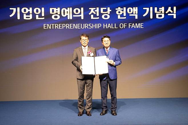김성태(왼쪽) IBK기업은행장과 박동석 산일전기 회장이 27일 서울 을지로 기업은행 본점에서 열린 ‘2025년 기업인 명예의 전당 헌액식’에서 기념촬영을 하고 있다. [기업은행 제공]