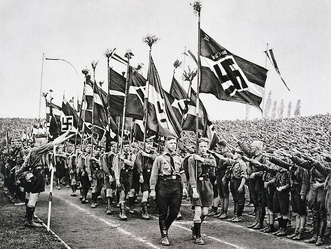 1933년 독일 나치당 행사에서 열린 '히틀러 유겐트' 집회에서 대원들이 나치 깃발에 '히틀러 경례'를 하고 있다./게티이미지