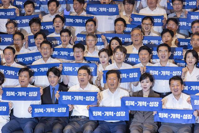정청래 대표와 김병기 원내대표를 비롯한 의원들이 28일 인천시 중구 파라다이스시티 컨벤션에서 열린 더불어민주당 의원단 워크숍에서 기념 촬영 도중 구호를 외치고 있다. [연합뉴스]