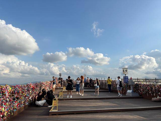 외국인 관광객이 25일 서울 용산구 남산서울타워 주변 난간에 걸린 자물쇠 앞에 삼삼오오 모여 있다. 김수미 인턴기자