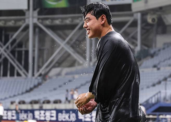 축하 물세례…나는 행복합니다 프로야구 한화 투수 문동주가 27일 서울 고척스카이돔에서 열린 키움과의 경기에서 데뷔 후 처음으로 시즌 10승을 거둔 뒤 동료들로부터 축하 물세례를 받고 웃고 있다. 한화 이글스 제공