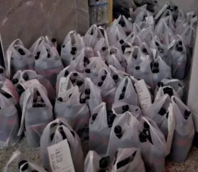 배달의 민족에서 신규 가입 고객에 15000원 할인 쿠폰을 배포한 가운데 한 가정집 앞부터 복도까지 콜라가 든 봉지로 채워져 있는 모습. [사진 = 온라인 커뮤니티 캡처]