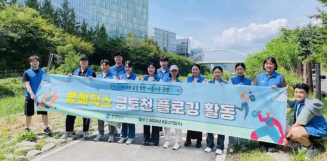 휴메딕스 임직원들이 27일 경기 성남 금토천에서 환경정화 활동 ‘플로깅’ 기념촬영을 하고 있다. [휴메딕스 제공]