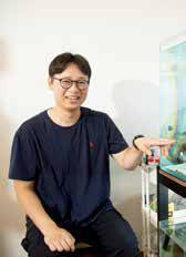 열대어가 있는 수조를 가리키며 미소 짓는 장웅기 씨.