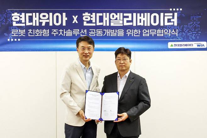 이원해 현대엘리베이터 승강기사업본부장(오른쪽)과 백익진 현대위아 모빌리티솔루션사업부장이 28일 오후 경기도 현대위아 의왕연구소에서 업무협약(MOU)을 체결한 뒤 기념촬영을 하고 있다.(사진=현대엘리베이터.)