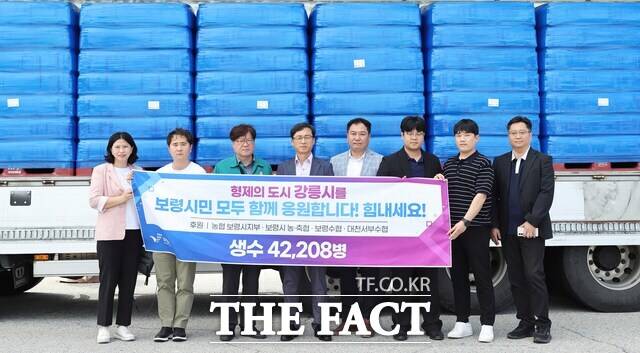 보령시가 극심한 가뭄으로 어려움을 겪는 자매도시 강릉시에 생수 4만 2208병을 긴급 전달하며 강릉시 관계자들과 기념촬영을 하고 있다. /보령시