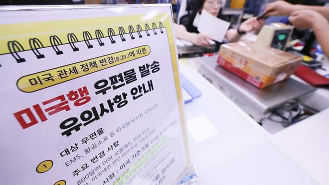 미국행 항공 소포 접수가 중단된 25일 서울 종로구 광화문우체국에 미국의 관세 정책 변경에 따라 미국행 국제우편 접수 단계적 중단 관련 안내문이 놓여 있다.