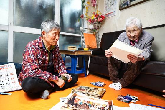 허정례 할머니(오른쪽)가 서울 노원구 자택에서 아들 김복희씨와 함께 옛날 사진을 보고 있다. 김종호 기자.