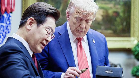 이재명 대통령이 25일(현지시간) 미국 워싱턴DC 백악관에서 열린 한미 정상회담에서 도널드 트럼프 미국 대통령에게 방명록 작성 때 쓴 만년필을 선물하고 있다. 김현동 기자