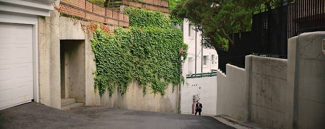 영화 ‘기생충’의 한 장면. 기우가 고액 과외 교사 면접을 보기 위해 박 사장이 사는 고급주택가 언덕길을 오르는 모습. 실제  촬영지는 성북구 성북동 선잠로8길로 알려졌다. [영화 기생충 갈무리]