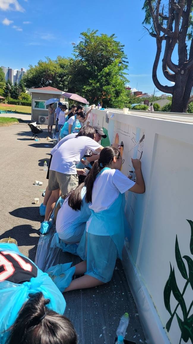 ▲ 구미여중 학생들과 초록별 아트스쿨 회원들이 구미여중 담장에 벽화그리기를 하고있다 이봉한기자