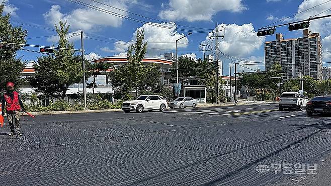 세계양궁선수권대회를 엿새 앞둔 30일 오전 광주 남구 주월동 광주국제양궁장 앞 도로. 공사현장 관계자들이 빨간색 복공판을 검은색으로 색칠하고 있다.