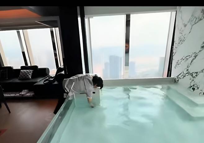 직원이 욕조의 물을 퍼내고 있다./사진=틱톡 캡처