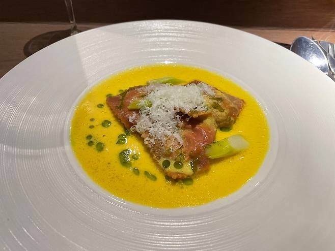 Onion raviolone filled with spring onion and white miso, wrapped in beet-stained dough and topped with dill oil and Pecorino (Hong Yoo/ The Korea Herald)