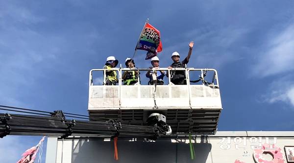지난 29일 경북 구미 한국옵티칼하이테크 옥상 농성장에서 600일 만에 고공농성을 마친 박정혜 수석부지회장이 크레인에 올라 손을 흔들며 인사하고 있다. 2025.8.29 구미/유혜연기자 pi@kyeongin.com