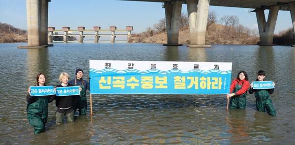 서울환경연합 관계자들이 한강에 입수해 신곡 수중보인 124m 가동보를 배경으로 '신곡수중보 철거하라'고 촉구하고 있다. 서울환경연합 제공