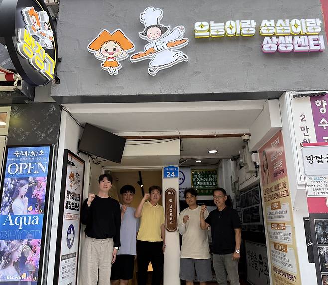 '으능이랑 성심이랑 상생센터'와 LG유플러스의 지역 상생 프로모션에 참여한 대전 은행동 일대 소상공인들이 기념 촬영을 하고 있다./사진=왕보경 기자