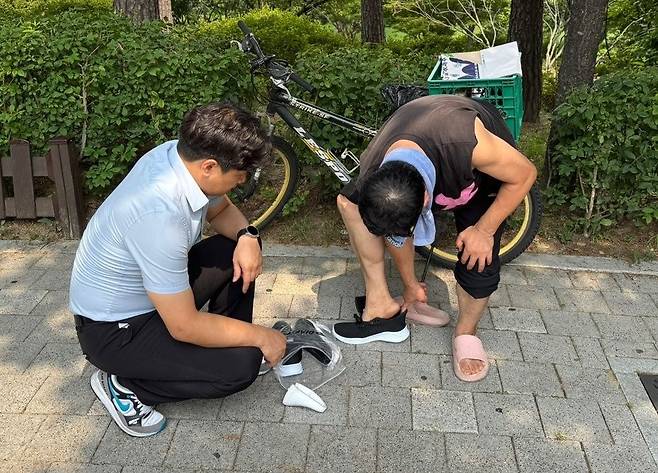 일산방주교회가 지난 2일 서울 영등포구 영등포공원에서 폭우로 신발이 망가진 노숙인에게 꼭 맞는 신발을 선물하는 장면. 교회 제공