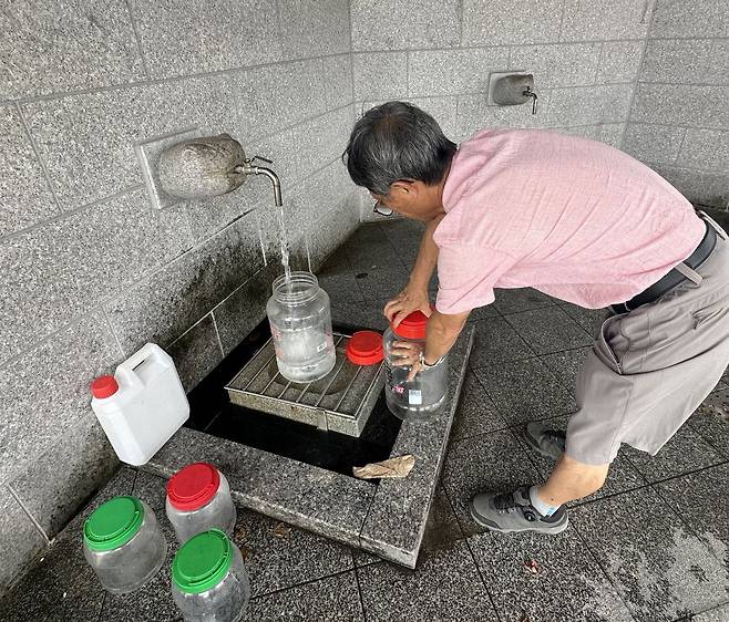 지난 30일 강원 강릉시 대관령샘터에서 시민이 물통에 식수를 받고 있다.
