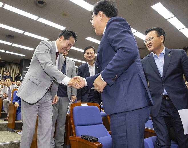 장동혁 국민의힘 대표가 27일 국회에서 열린 의원총회에 입장하며 동료 의원들과 인사하고 있다. [사진 출처 = 연합뉴스]