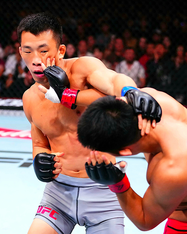 AFC 웰터급 챔피언 김상욱과 중국 우슈 산타 전우훈 전국대회 우승자 런야웨이가 2025년 8월 상하이다우타이 Road to UFC 시즌4 라이트급 토너먼트 4강전에서 공격을 주고받고 있다. 사진=TKO