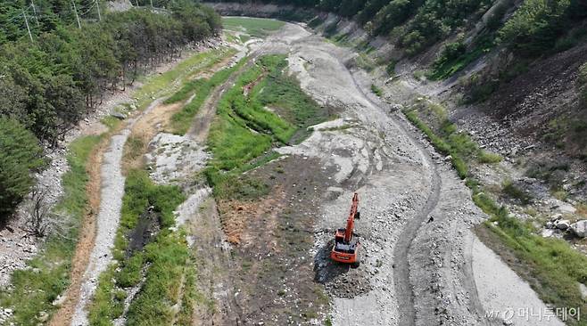 (강릉=뉴스1) 김성진 기자 = 강원 강릉지역이 사회재난이 아닌 자연재난으로는 사상 첫 재난 사태 지역으로 선포됐다.  행정안전부는 30일 오후 7시부로 극심한 가뭄을 겪고 있는 강원 강릉시 일원에 재난사태를 선포했다. 31일 한국농어촌공사 농촌용수종합정보시스템에 따르면 이날 오전 7시 40분께 오봉저수지 저수율은 14.9%로, 전날 15.3%에서 0.4%포인트 떨어졌다.  식수 공급의 마지노선으로 여겨진 저수율 15% 선이 무너지면서 강릉시는 수도 계량기 75%를 잠그는 제한 급수를 본격적으로 시행한다.  31일 강원 강릉시 주요 상수원인 오봉저수지 상류에서 한 관계자가 포크레인으로 물길을 내고 있다. 2025.8.31/뉴스1  Copyright (C) 뉴스1. All rights reserved. 무단 전재 및 재배포,  AI학습 이용 금지. /사진=(강릉=뉴스1) 김성진 기자