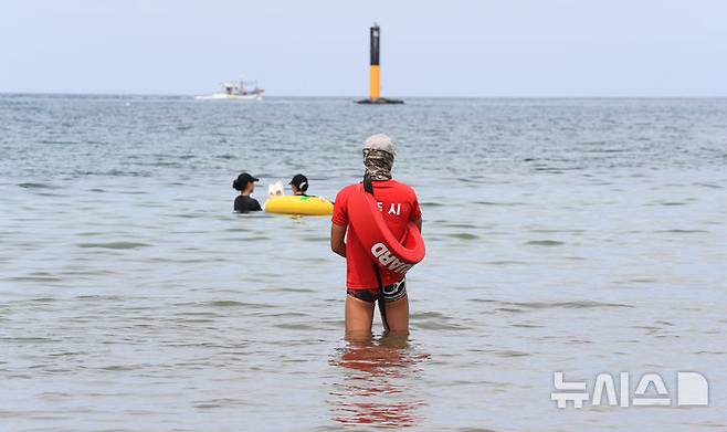 [제주=뉴시스] 우장호 기자 = 제주 도내 12개 지정해수욕장이 폐장하는 31일 오후 제주시 이호테우해숙장에서 안전요원이 물놀이객을 살피고 있다. 2025.08.31. woo1223@newsis.com