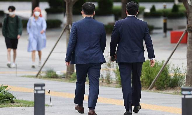 정장 재킷을 입은 시민들이 서울 종로구 광화문역 인근에서 길을 걷고 있다. 연합뉴스