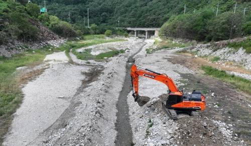 31일 강원 강릉시 주요 상수원인 오봉저수지 상류에서 한 관계자가 굴착기로 물길을 내고 있다. 2025.8.31. 뉴스1