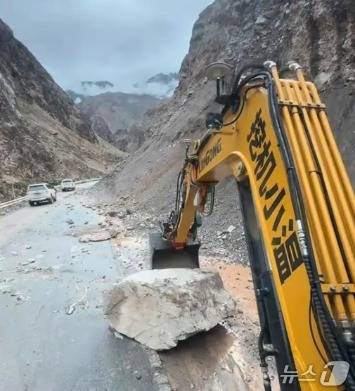 도로의 바위를 치우는 모습 - SCMP 갈무리