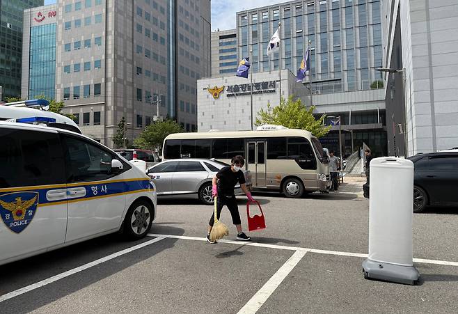지난 18일 오후 청소 노동자 A씨가 서울 강남경찰서 주차장 앞 인도를 빗자루로 쓸고 있다. 강남서는 연면적 2만여 ㎡의 서울 최대 경찰서지만, 이곳을 청소하는 사람은 단 세 명뿐이다. A씨는 “새벽에 나와 화장실과 복도, 계단을 치우다 보면 쉴 시간 없이 하루가 간다”고 했다./조인원 기자
